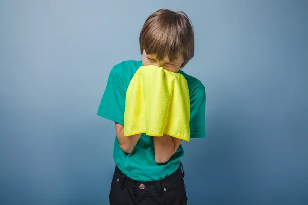 Europäisch aussehender Junge von zehn Jahren ist krank, ein Taschentuch auf dem Kopf — Stockfoto