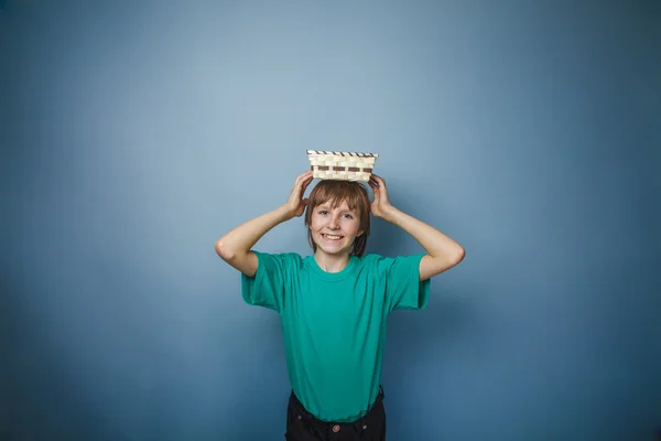 European -looking  boy of ten years holding an empty basket in h — Stock Photo, Image