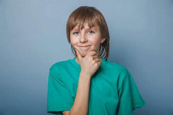 European-looking boy of ten years thinking, hand under his chin — Stock Photo, Image