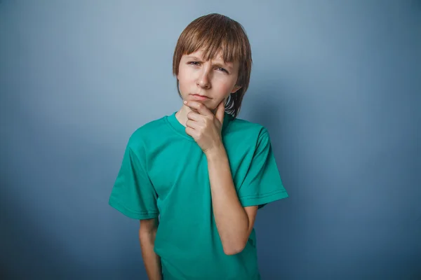 Europäisch aussehender Junge von zehn Jahren denkt, die Hand unter dem Arm — Stockfoto