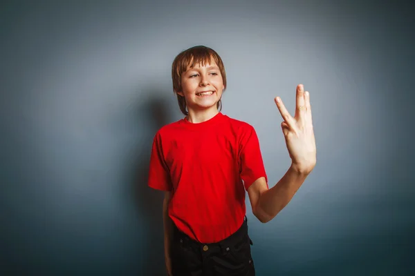 Boy teenager European appearance in a red shirt showing thumbs d — Stock Photo, Image