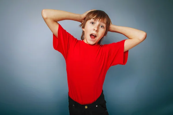 Boy teenager European appearance in a red shirt put his hands be — Stock Photo, Image