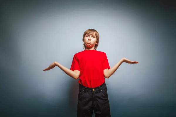 Boy teenager European appearance in a red shirt spread his arms — Stock Photo, Image