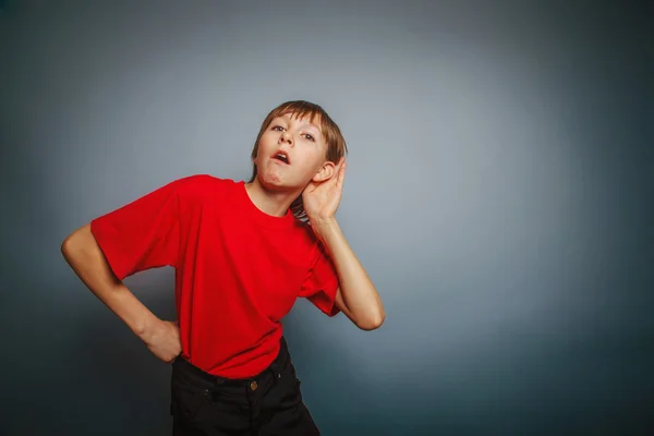 Europeo apariencia chico escucha una década, interés, oreja en gra — Foto de Stock