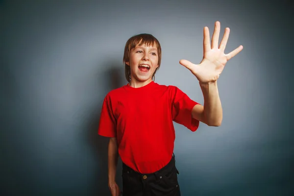 Europäisch aussehender zehnjähriger Junge zeigt eine Figur mit fünf Fingern — Stockfoto