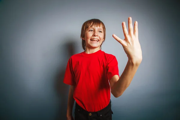 Niño de aspecto europeo de diez años muestra una figura de cuatro dedos en —  Fotos de Stock