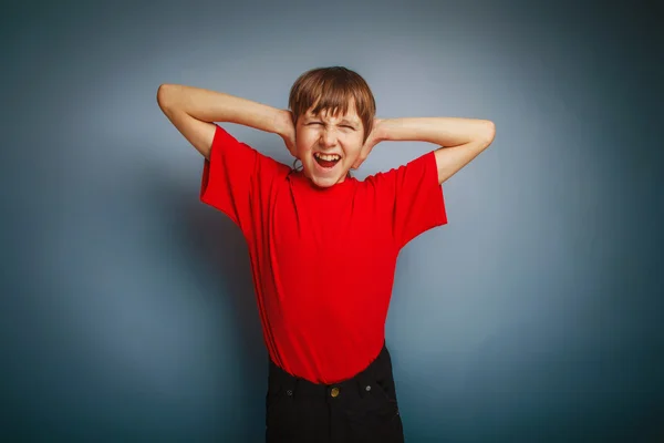 Jongen tiener Europese verschijning in een rood shirt gedekt zijn oren — Stockfoto