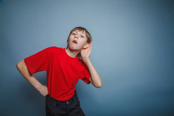 Europeo apariencia chico escucha una década, interés, oreja en gra — Foto de Stock