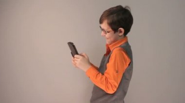 çocuk genç oyun tablet gri arka plan üzerinde bardaklarda sürpriz keskin