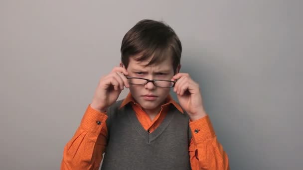Angry teenager puts on his head boy wears glasses ten years — Stock Video