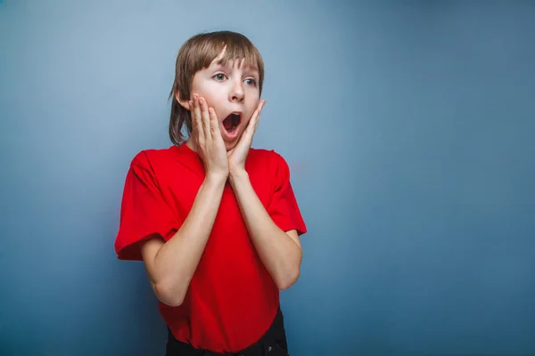 Niño, adolescente, doce años en camisa roja sorprendió boca abierta — Foto de Stock