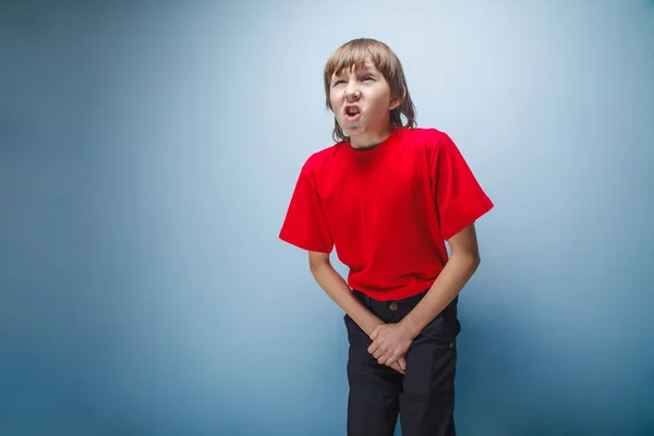 Menino, adolescente, doze anos de camisa vermelha quer usar banheiro , — Fotografia de Stock