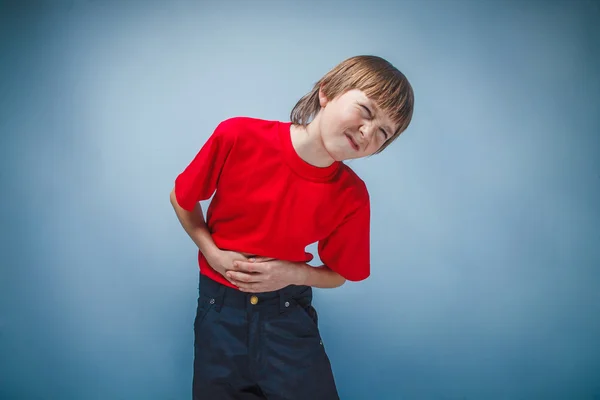 Boy remaja dua belas tahun di kemeja merah sakit perut, gastriti — Stok Foto