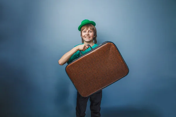 European-looking boy of ten years with a suitcase in a hat on a — Stock Photo, Image