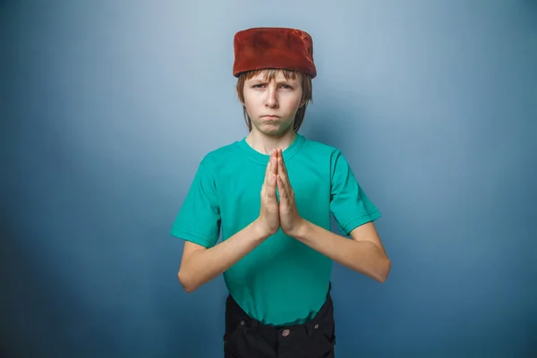 Muslim boy of ten  years, skullcap, prayer on a gray background — Stock Photo, Image