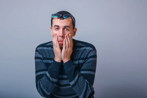 Man van Europees uiterlijk zwart haar ogen strekt zich met zijn h — Stockfoto