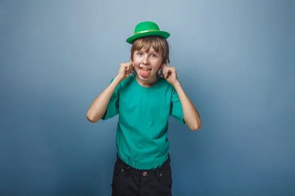 Europees uiterlijk tiener jongen in T-shirt met groen hoed stret — Stockfoto