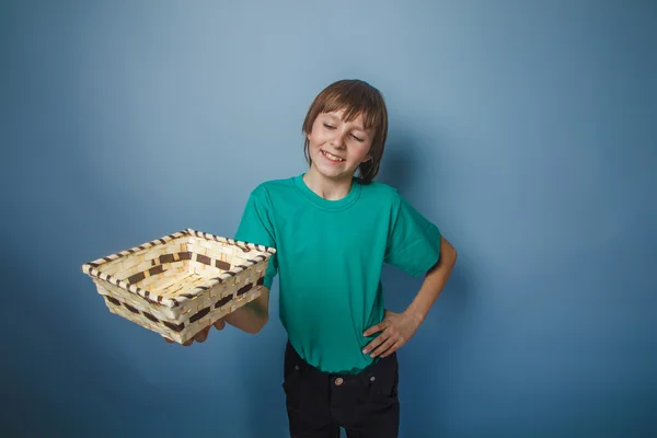 Boy teenager European appearance brown hair in a shirt holding a — Stock Photo, Image