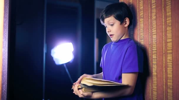 Nastolatek chłopiec dziecko czyta książki, stałego ścianę w Apartament strony rzut — Wideo stockowe