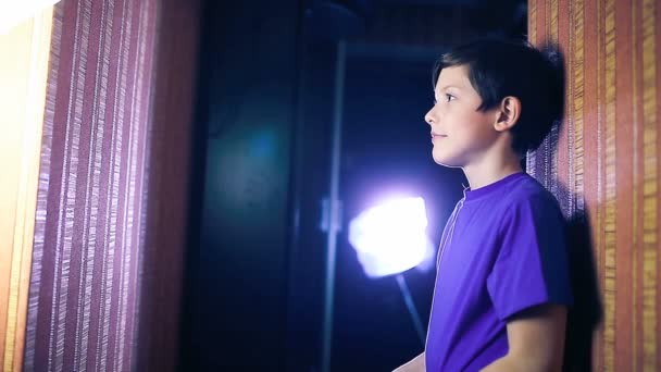 Adolescente menino criança lê livro, de pé contra página de parede lançando — Vídeo de Stock