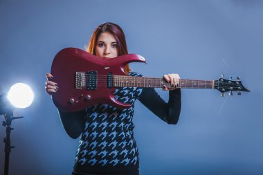 Avrupa görünümlü kız yirmi yıllık bir gitar tutarak onun ha