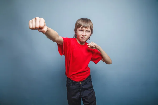 Boy, teenager, twelve years  red  in shirt, red showing  fists h — Stock Photo, Image