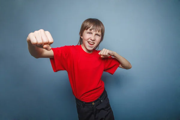 Chlapče, teenager, dvanáct jeho červená košile, pěsti červené zobrazeno y — Stock fotografie