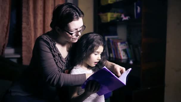 Mamá con gafas mujer y su hija hacer tarea adolescente chica lectura libro decidir hoja — Vídeo de stock