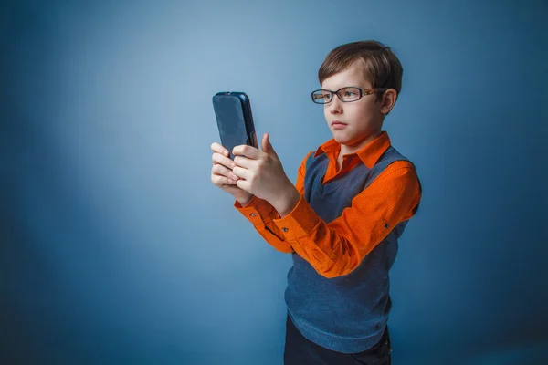 Europeiska-ser pojke på tio år i glas ser på plattan — Stockfoto