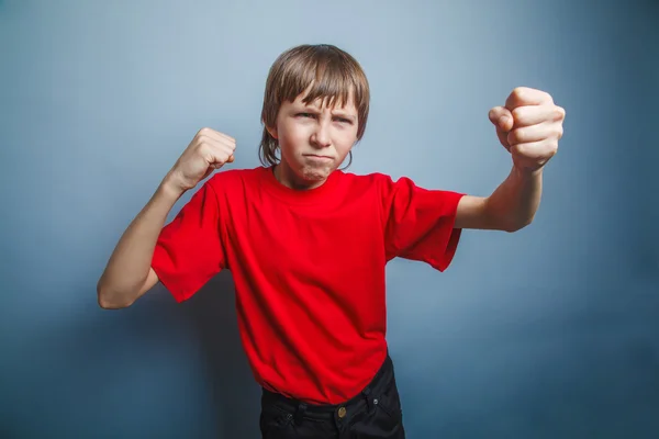 Rapaz de dez anos de aparência europeia mostra um punho, raiva, ameaça — Fotografia de Stock