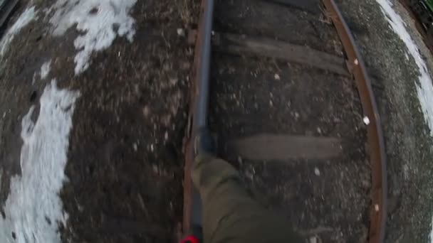 Hombre camina por ferrocarril viaje piernas en botas video gopro — Vídeo de stock