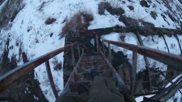 Homme descend les escaliers un vieux abandonné chemin de fer vidéo à la première personne hiver GoPro — Video