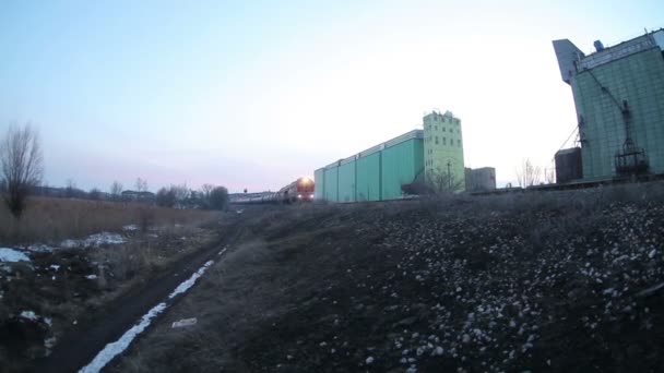 Güterzug transportiert Ölfässer in Waggons, Video vom Winterabend — Stockvideo