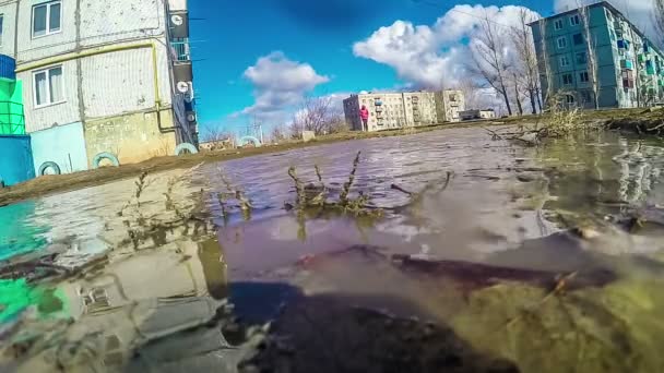 Városkép orosz tavaszi sár pocsolya napos öt emeletes épület, fűtési fő cső, kék ég videóinak gopro hd1920x1080 — Stock videók