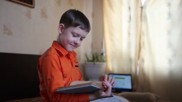 Підліток хлопчик читає книгу десять років дивиться посмішки відео HD 1920x1080 — стокове відео