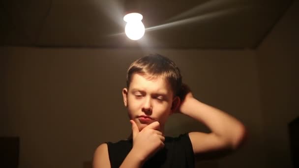 Adolescente ragazzo dieci anni pensa lampadina oltre la sua testa l'idea di un scuro sfondo video 1920x1080 hd — Video Stock