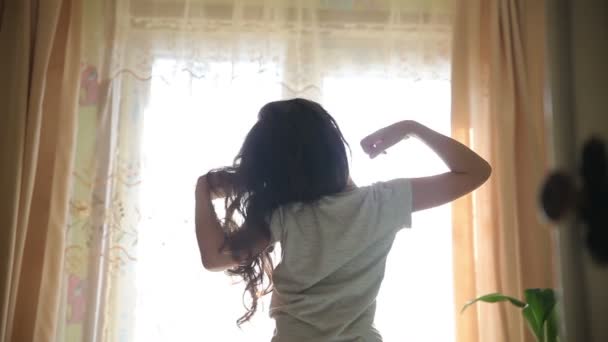 Adolescente menina se estende acordado de pé na silhueta da janela spin vídeo hd 1920x1080 estilo de vida — Vídeo de Stock