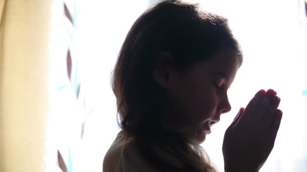 Child teen girl praying prays silhouette in window video hd 1920x1080 — Stock Video