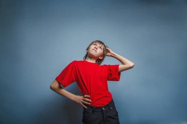 Niño, adolescente, doce años en camisa roja, pensativo, derzhet h —  Fotos de Stock