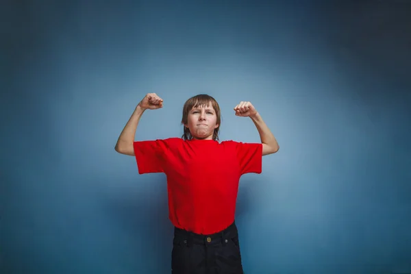 Menino, adolescente, doze anos de camisa vermelha, mostrando força — Fotografia de Stock