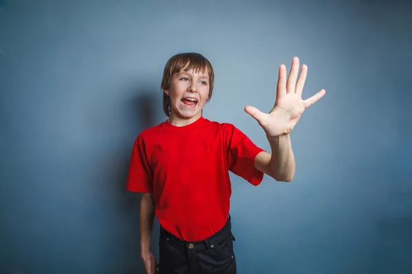 Pojke, tonåring, tolv år gammal, i en röd skjorta, visar hand — Stockfoto