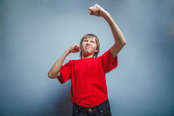 Boy, teenager, twelve years  red  in shirt, showing  fists his — Stock Photo, Image