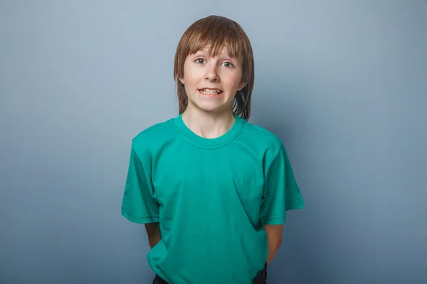 Ragazzo, adolescente, dodici anni in una maglietta verde, mostrando i denti s — Foto Stock