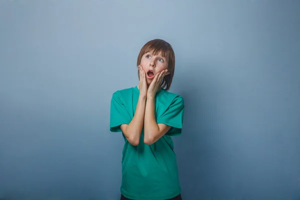 Junge, Teenager, zwölf Jahre im grünen T-Shirt, hält seine Hand — Stockfoto