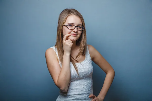 Woman with glasses in a white dress and looks  aside, thinking — Stock Photo, Image