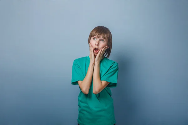 Junge, Teenager, zwölf Jahre in einem grünen hält seine — Stockfoto