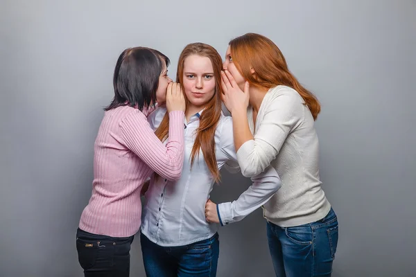 Три жінки жінка друзі дівчина плітки чутки сюрприз на сірому фоні — стокове фото