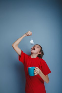 çocuk genç kırmızı gömlekli Avrupa görünüm bir mavi Kupası tutar