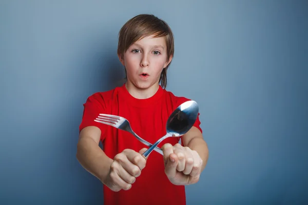 Boy teenager European appearance in a red shirt holding a fork a — Stock Photo, Image