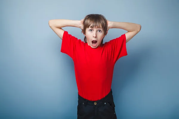 Ragazzo adolescente aspetto europeo in una camicia rossa ha aperto la bocca — Foto Stock